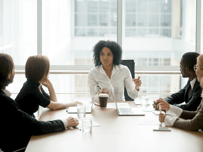Woman sat at head of board table