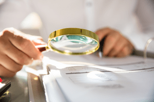 Documents being viewed through a magnifying glass