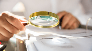 Documents being viewed through a magnifying glass