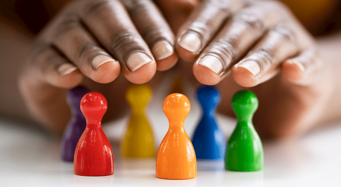 Hands above multi-coloured chess pawns
