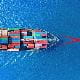 A cargo ship sailing on deep blue water, viewed from above. The vessel is loaded with colourful shipping containers arranged in neat rows, creating a striking contrast against the surrounding ocean.