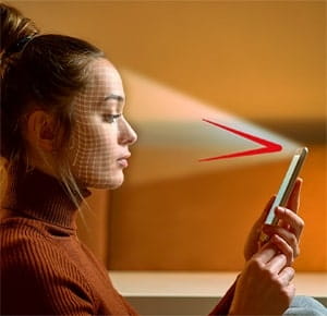 A person holding a smartphone in one hand, with a bright triangular beam of light projected from the phone toward the person’s eyes. The background is softly lit in warm tones.