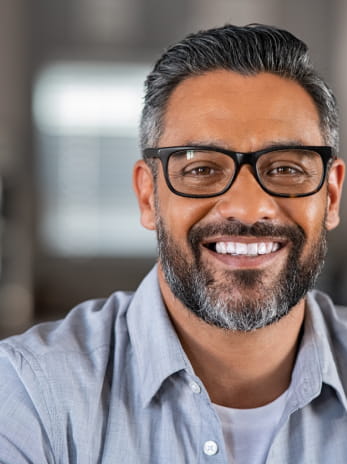 Man in glasses smiling at camera