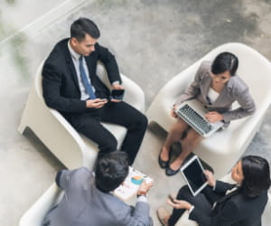 Four business people sitting in a circle having a meeting