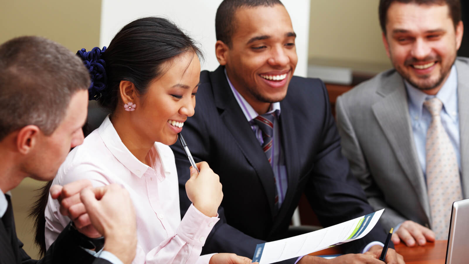 Four people in suits having a discussion