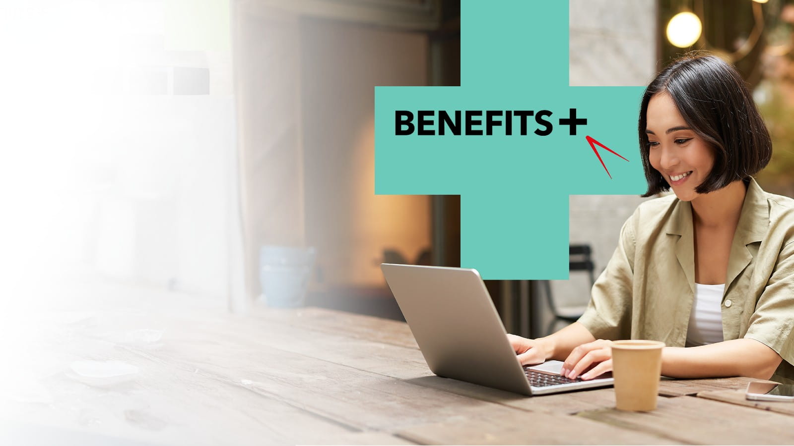 A woman working on her laptop smiling at her disk, BenefitsPlus logo positioned next to her