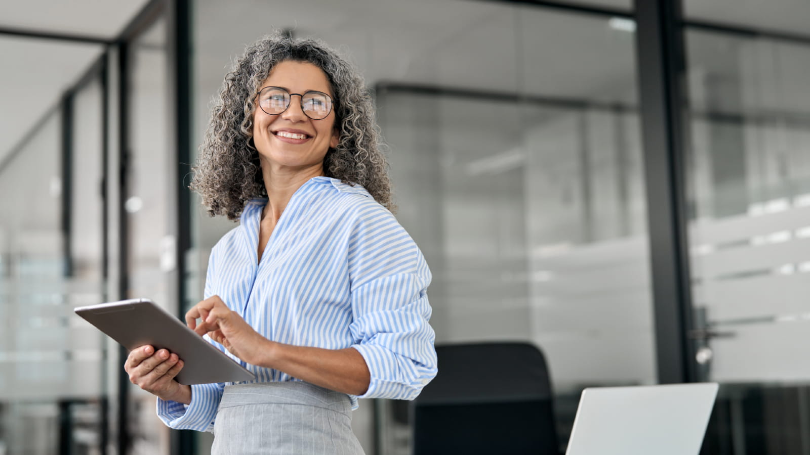 Woman standing with a tablet in her hand, smiling