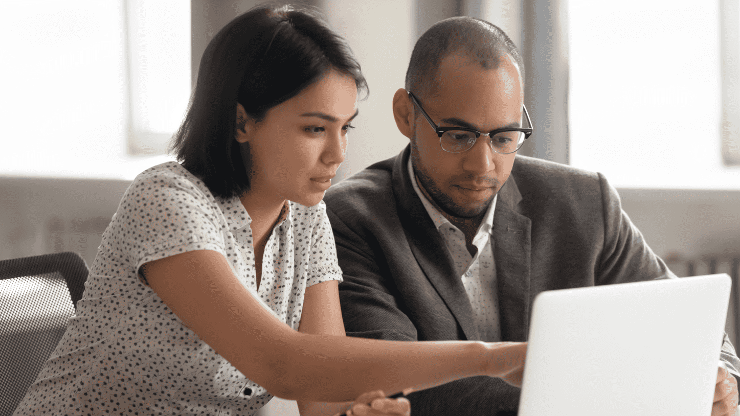 A woman and man looking at a laptop