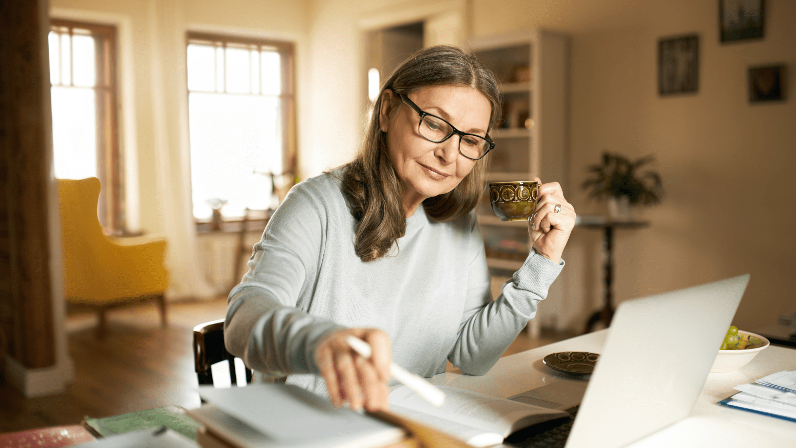Woman with a teacup, using a laptop