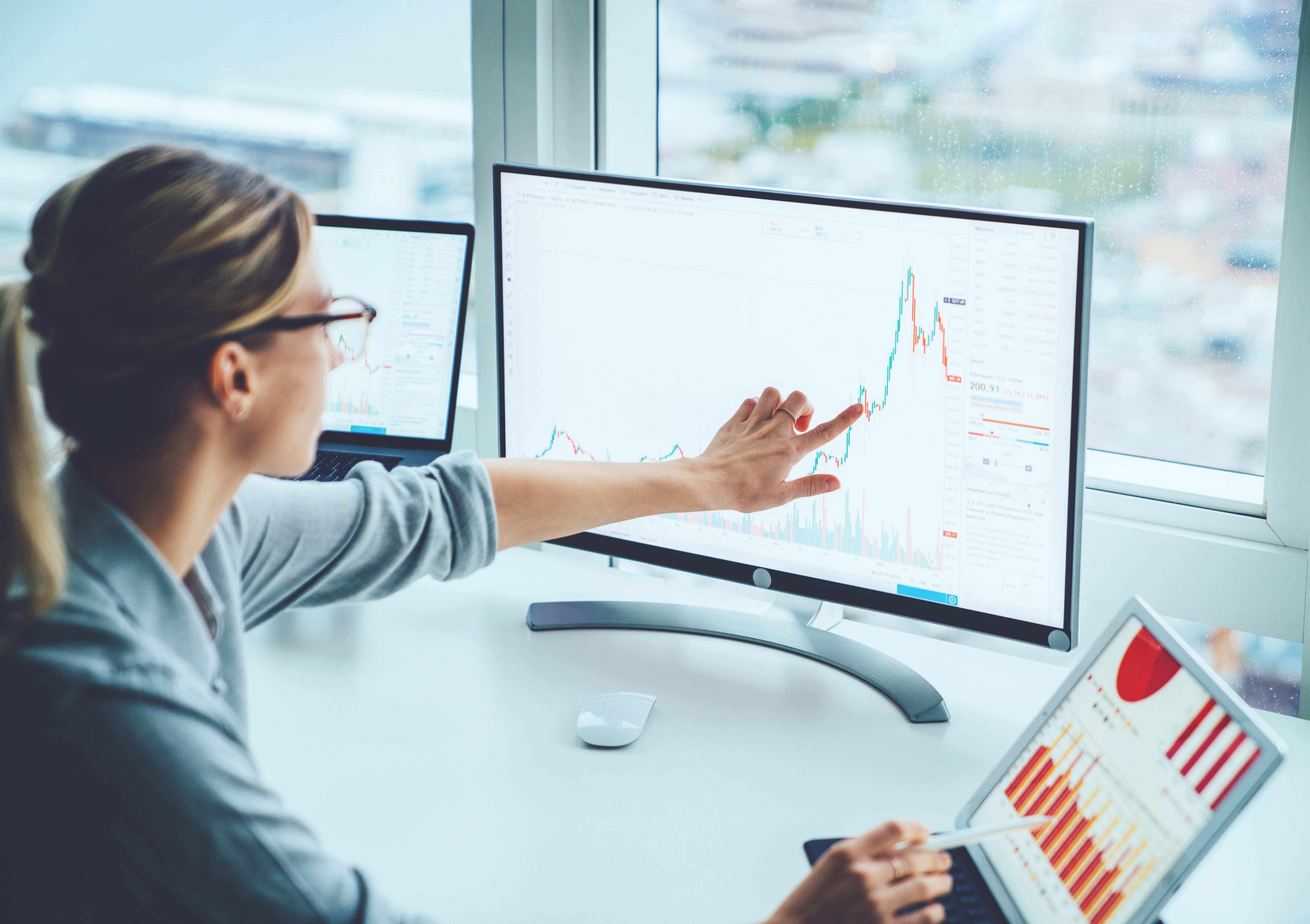 A person looking at graphs on computer screens