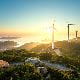 wind farm turbines sunset blue sky green land ocean sea