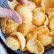 crisps chips shells poppadoms in a bowl hand reaching picking