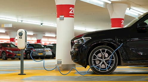 An electric car charging in a car park