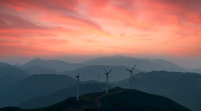 Three wind turbines in a dusky landscape