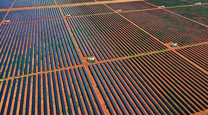 A vast field filled with rows upon rows of solar panels