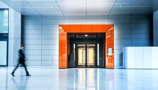 A businessperson walking in an office lobby 
