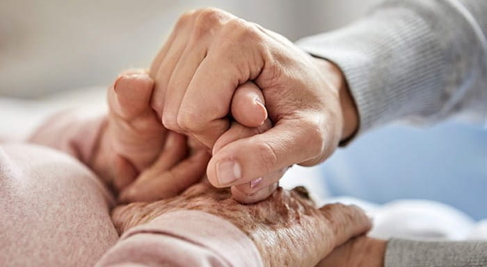 A person holding hands with an elderly person