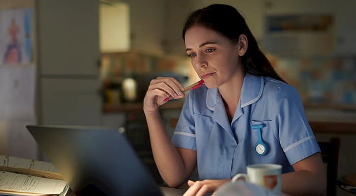 A nurse working at a laptop