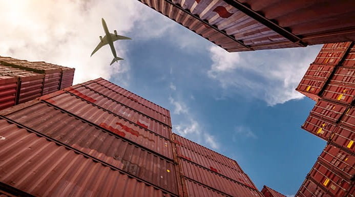 Plane flying over cargo containers 
