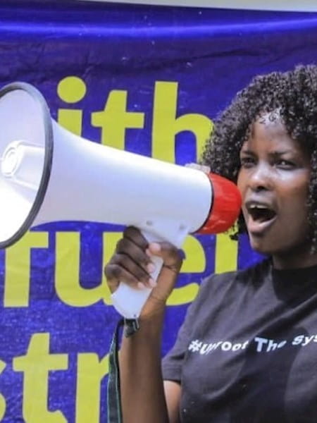 A stillframe from the video, showing Evelyn Acham speaking at a rally.