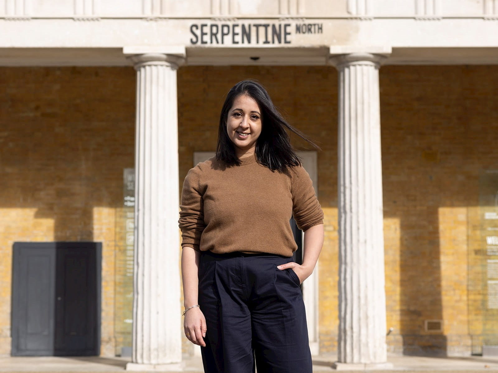 Alina Cummins, Head of Finance at Serpentine, young woman standing in front of Serpentine building columns north