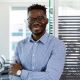 young man wearing glasses smiling blue shirt office employee