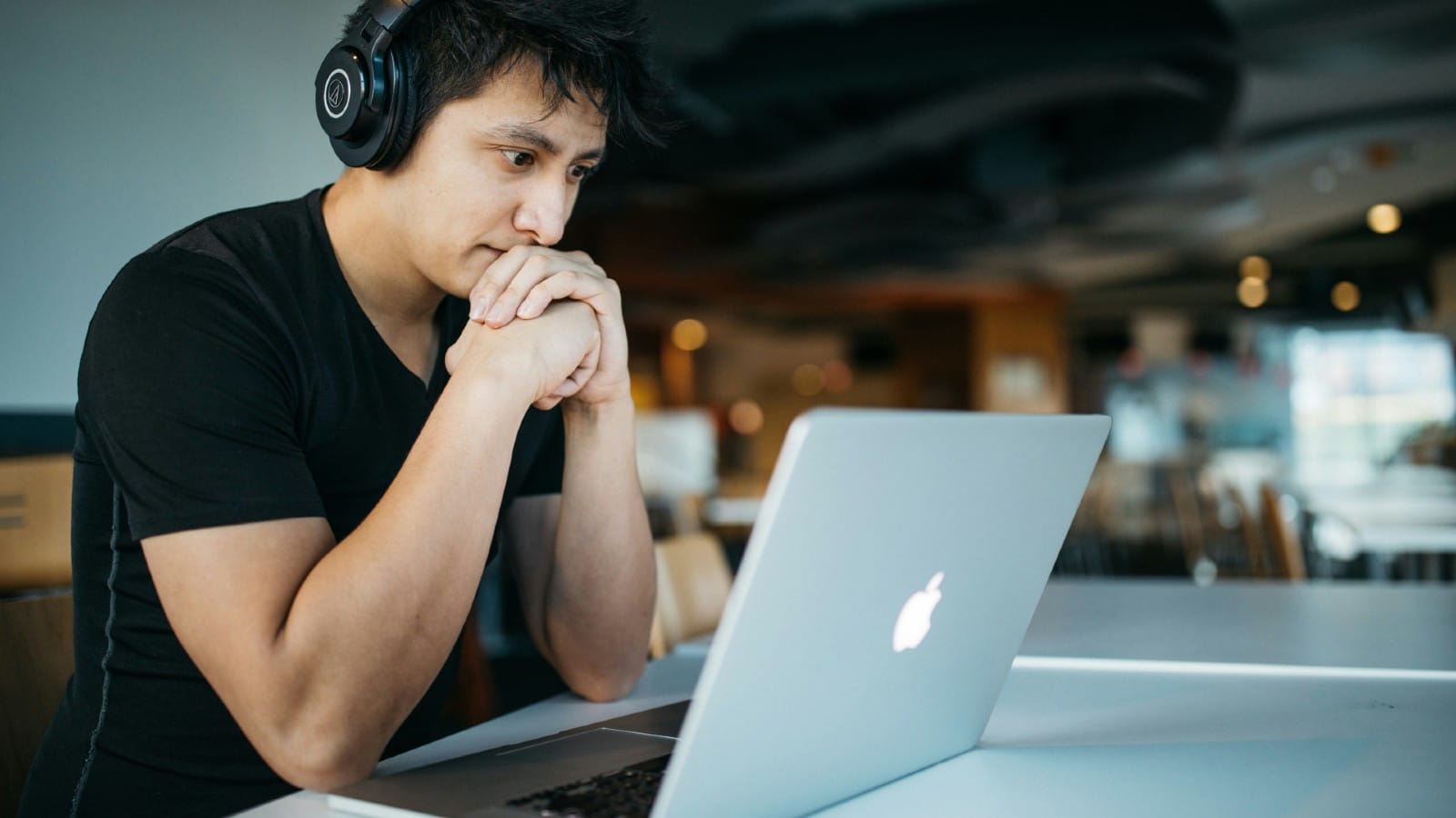 Male wearing headphones working on his laptop