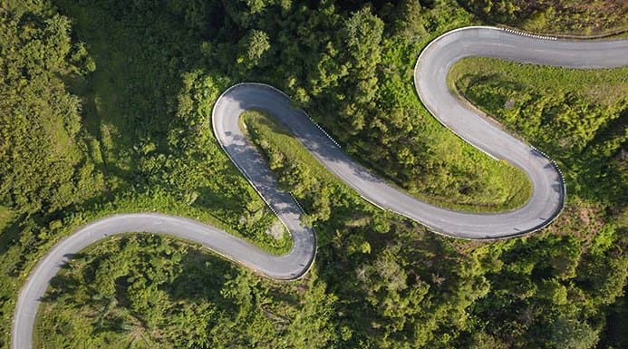 Aerial photo of a winding road surrounded by green countryside