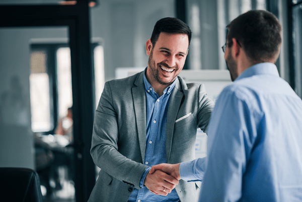 male shaking hands with a colleague at work