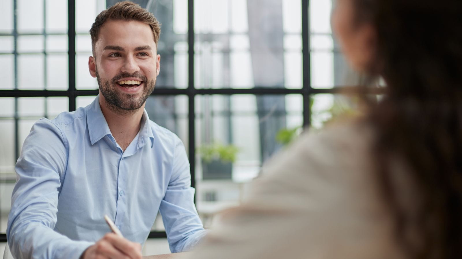 young businessman at desk smiling