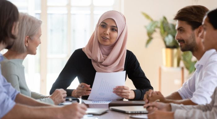 Image of workers sat around a table