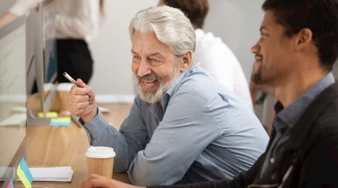 Image of older co-worker advising younger