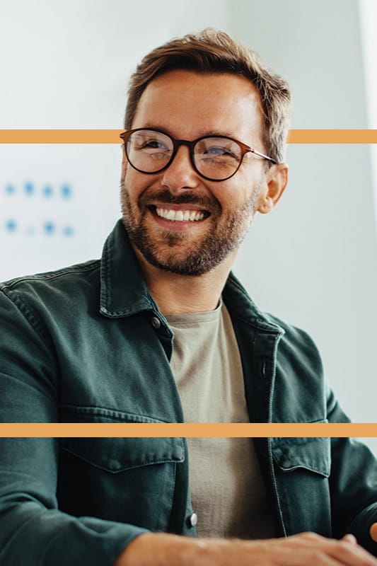 Image of a smiling casually dressed man wearing glasses