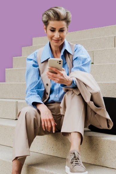 Image of a woman sitting on stairs looking at a phone