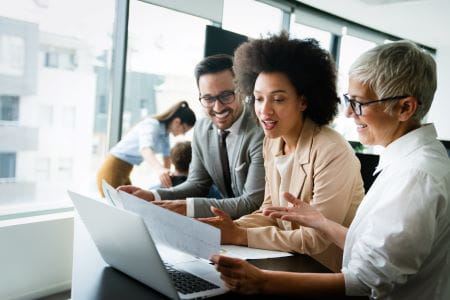 People looking at a laptop in an office