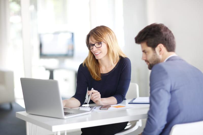 Woman and man working at a laptop in modern looking office