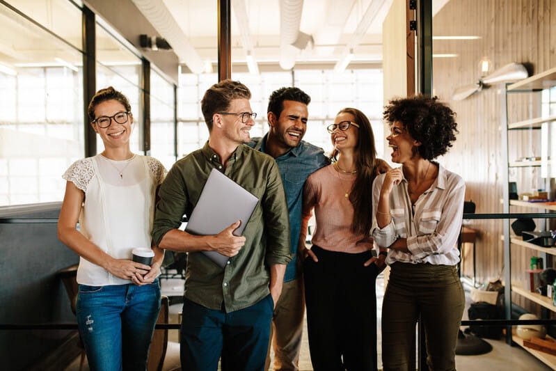 Diverse black and white young business people laughing and smiling together.