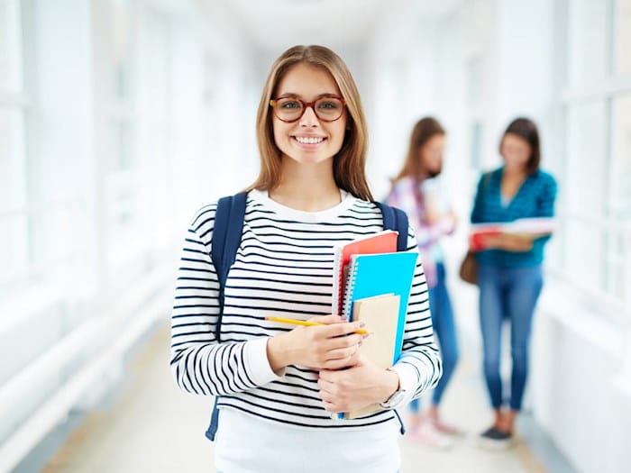 Young female college student in blue-and-white top, holding files