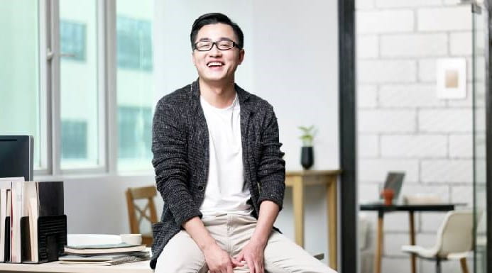 Young Asian businessman sitting on desk