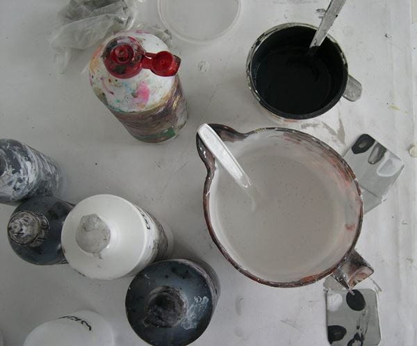 Image shows a selection of paints ready to use on a painting