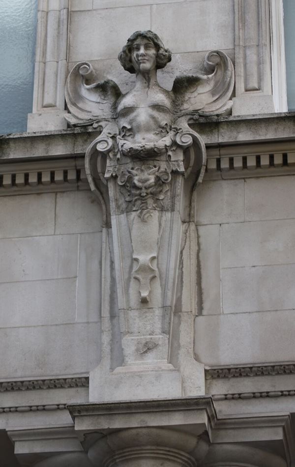 Photograph of a stone carved angel on the building exterior