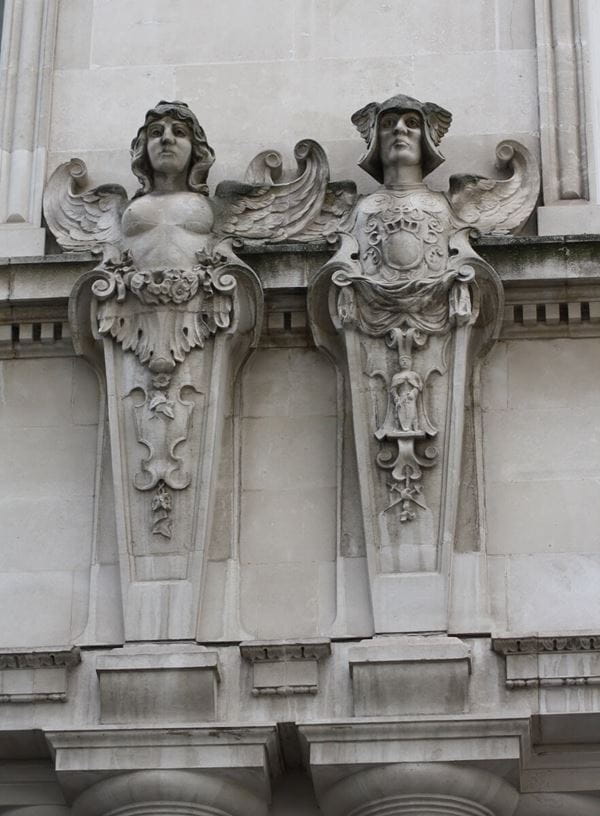 Photograph of two stone carved angels on the building exterior