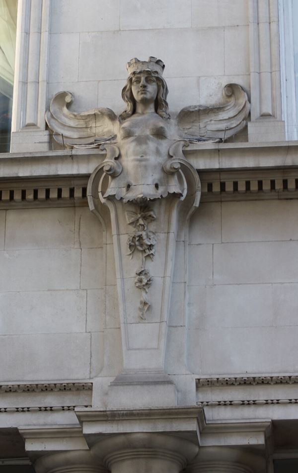 Photograph of a stone carved angel on the building exterior