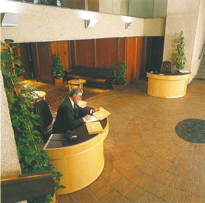  picture of the lobby of a modernist building with red floor tiles