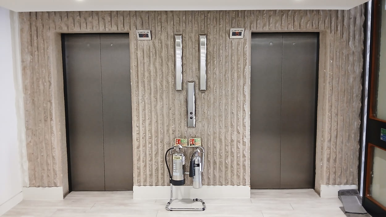 a picture of two elevators in a concrete wall