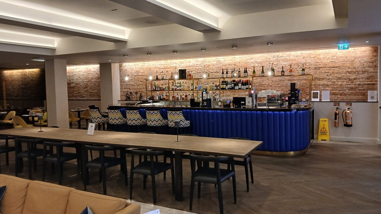 An empty bar, with a bare brick wall behind the bar