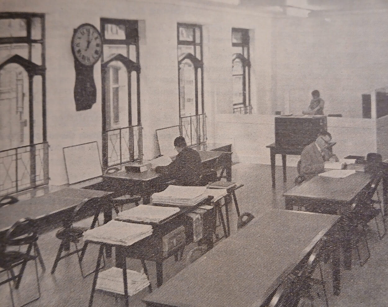 vintage black and white picture of some men reading at desks in a library