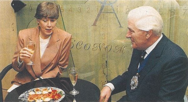 Man and a woman and a ttable with glasses of wine and some food