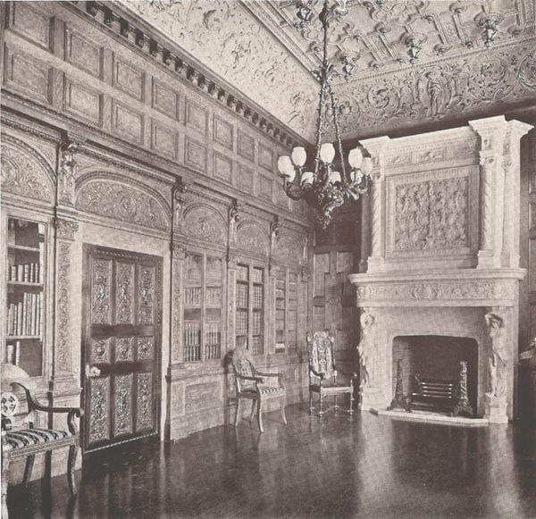 A black and white photograph of an ornate room with chandeliers and a fireplace