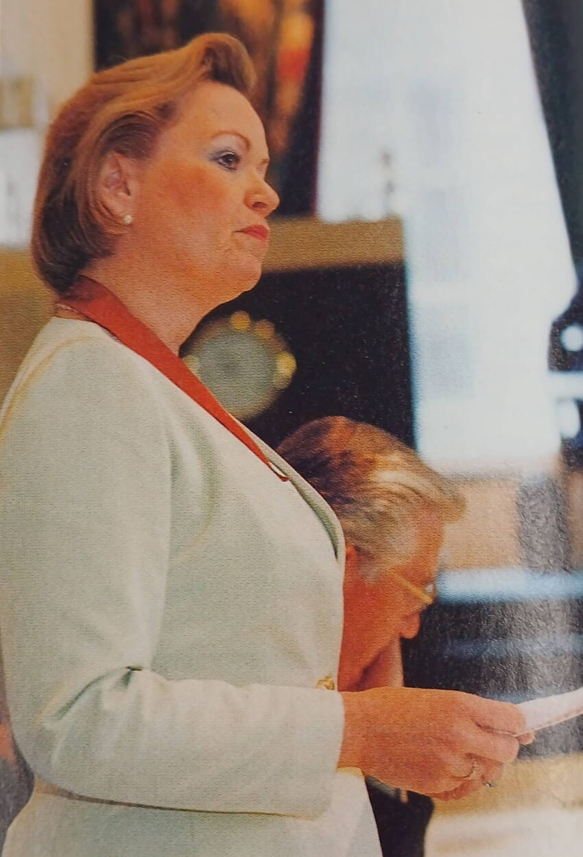 A photograph of a middle aged woman looking to the right